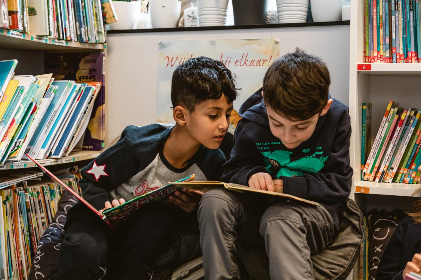 twee leerlingen kijken samen in een prentenboek