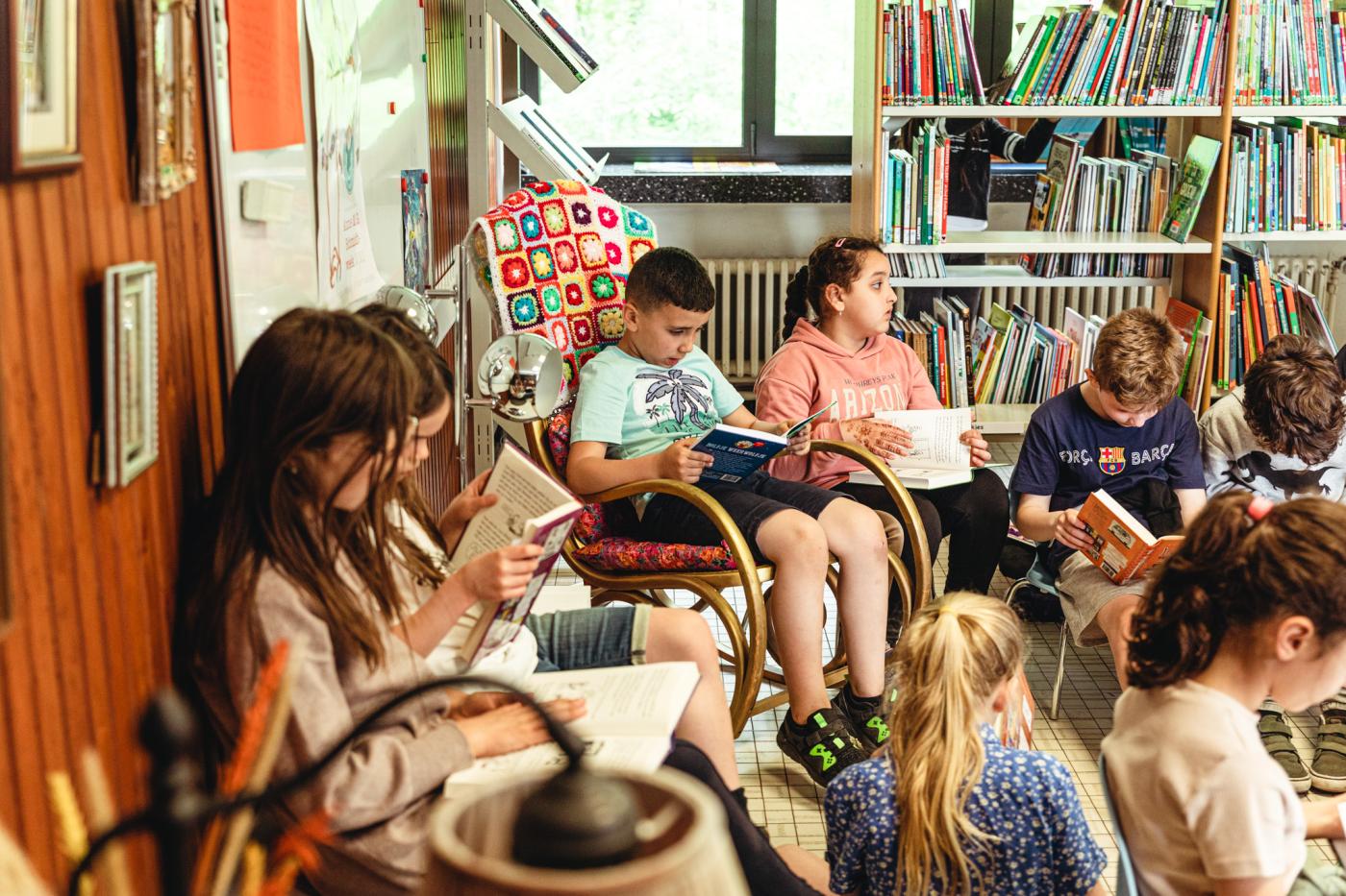 afbeelding van zittende leerlingen die een boek lezen