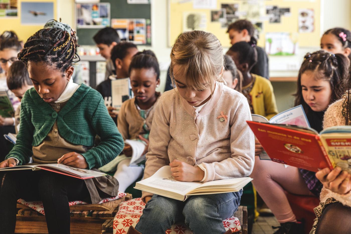 afbeelding van zittende leerlingen die een boek lezen