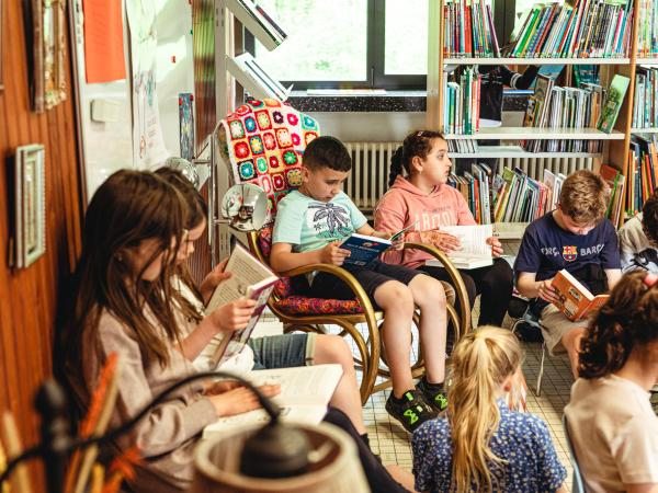 afbeelding van zittende leerlingen die een boek lezen