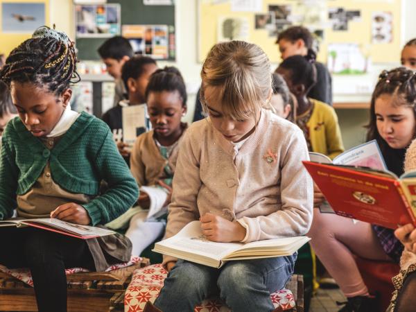 afbeelding van zittende leerlingen die een boek lezen